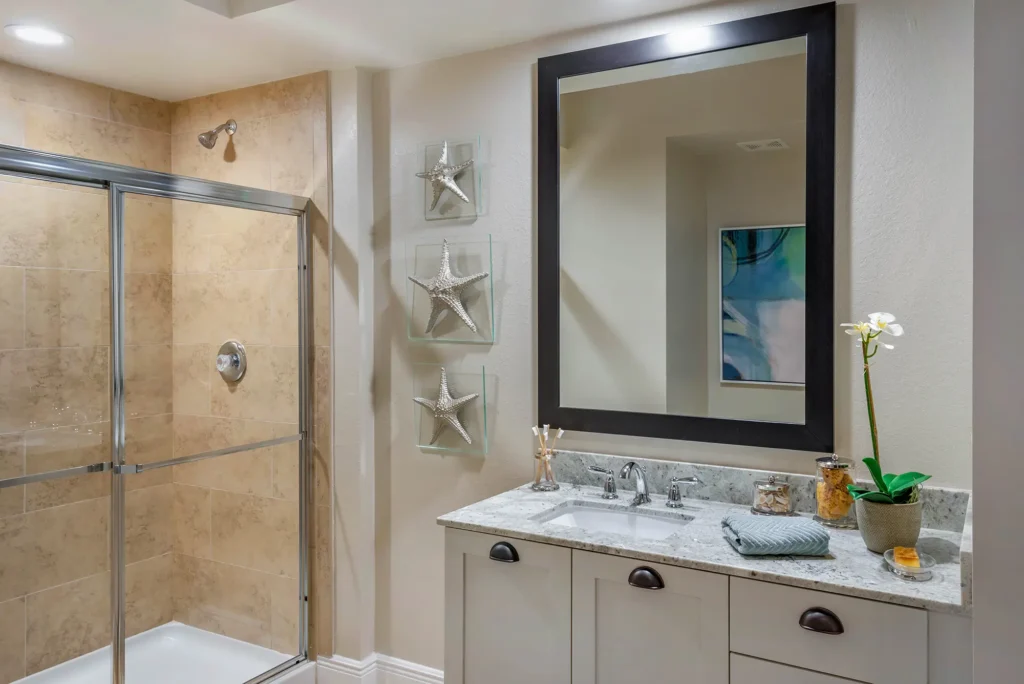 Bathroom with large mirror, granite countertop and tiled shower