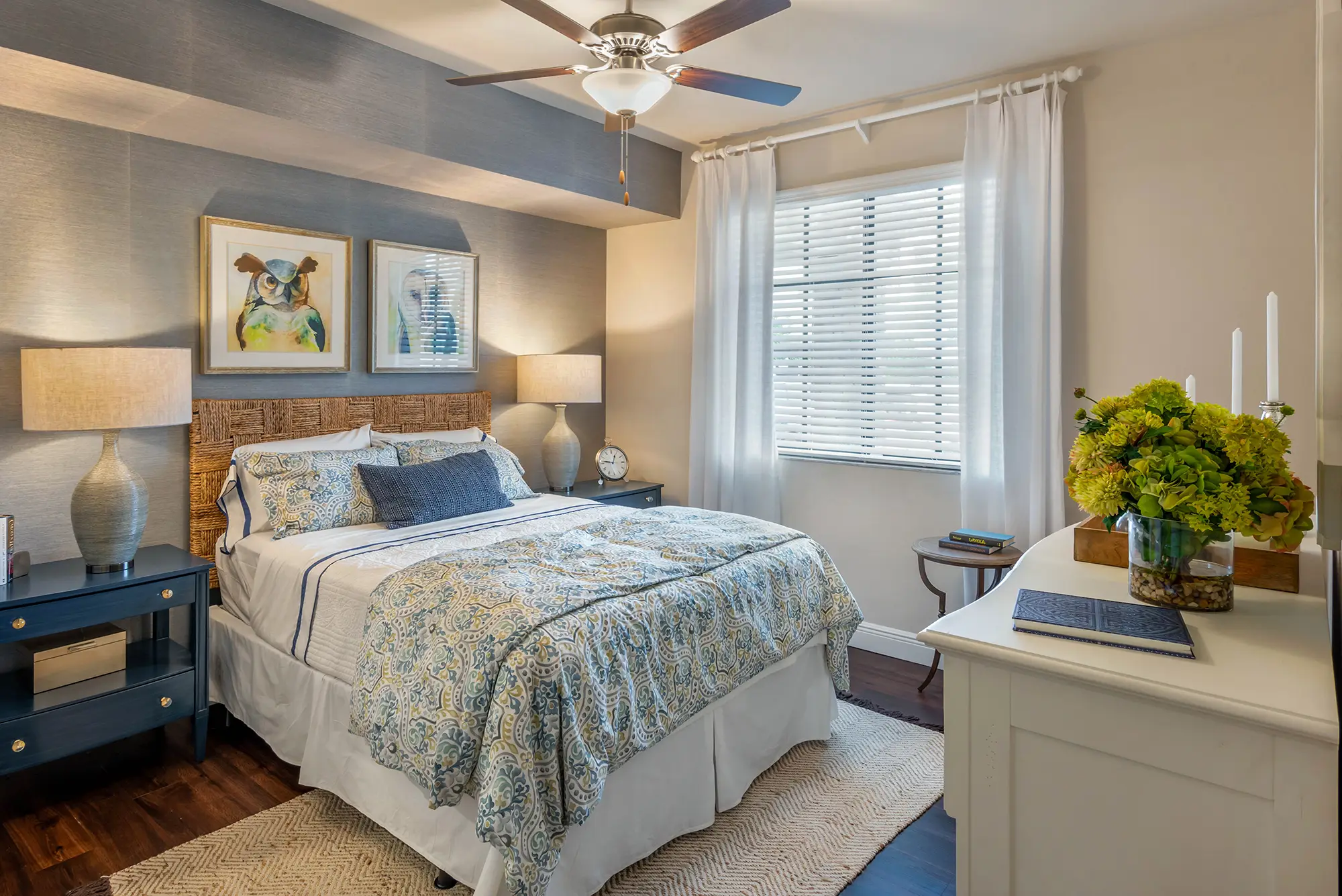 Bedroom with ceiling fan window and accent wall