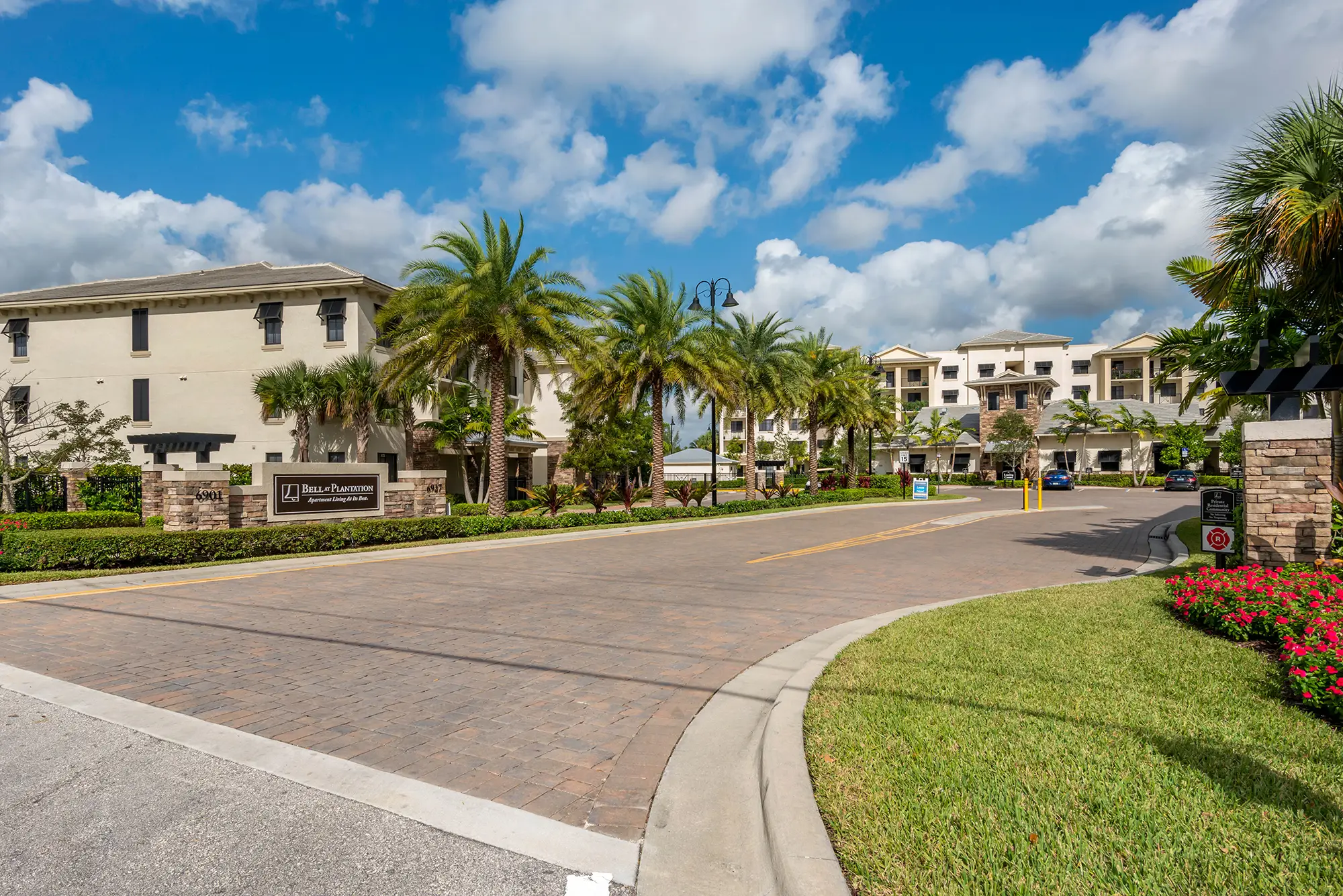 Entrance to apartment community with palm trees.