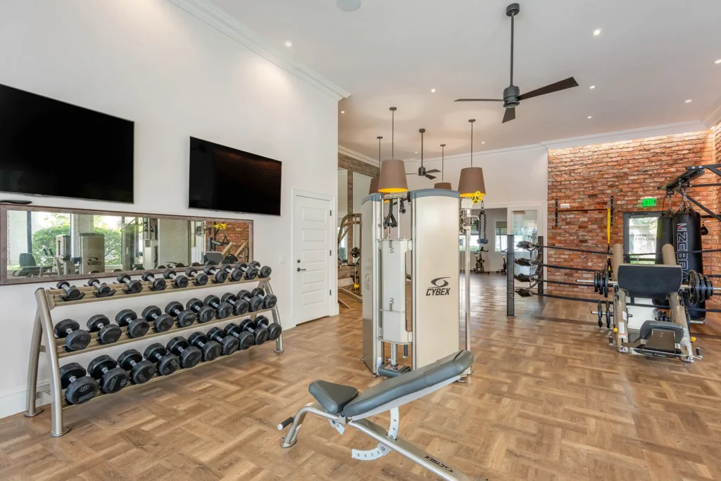Fitness center with strength training equipment and tvs.