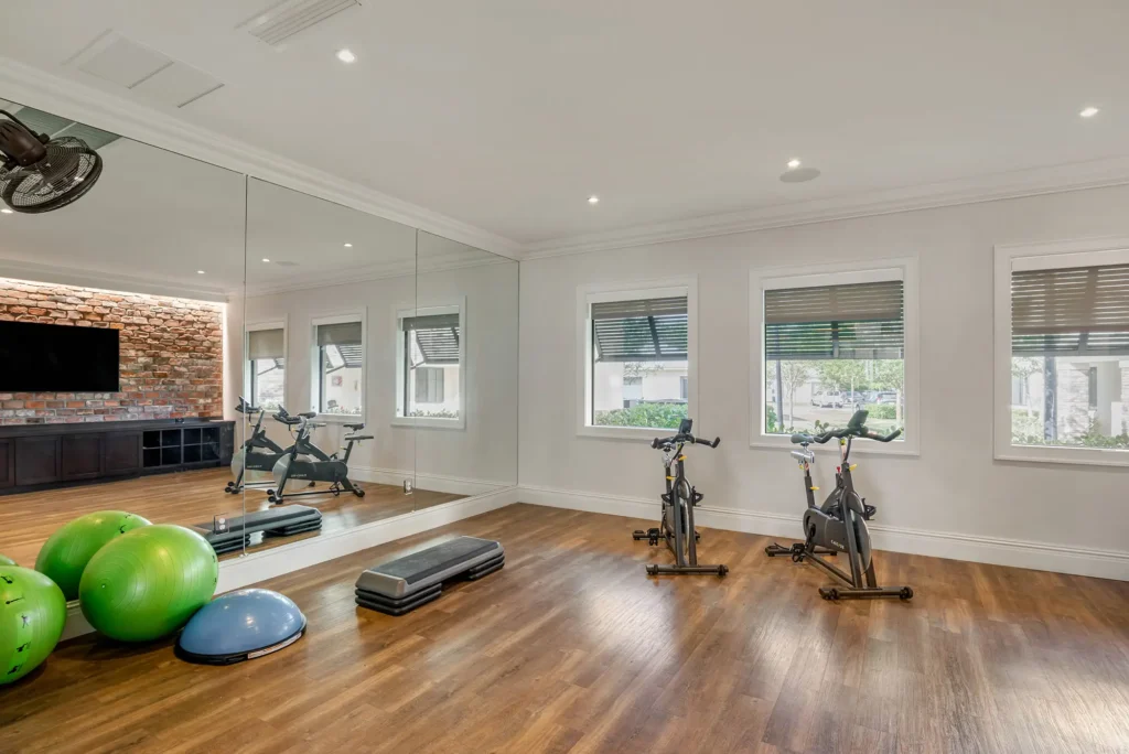 Fitness centers with indoor bikes, mirror wall, stretching equipment, and tv.