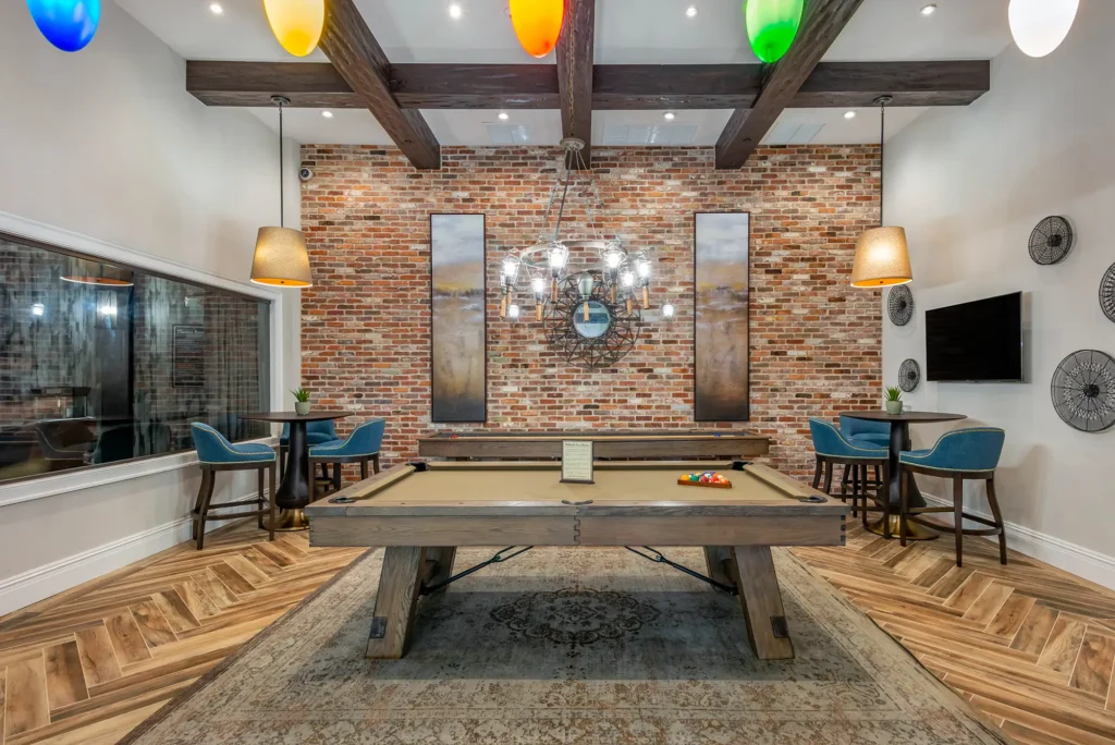 Indoor clubhouse area with pool table and shuffleboard table.
