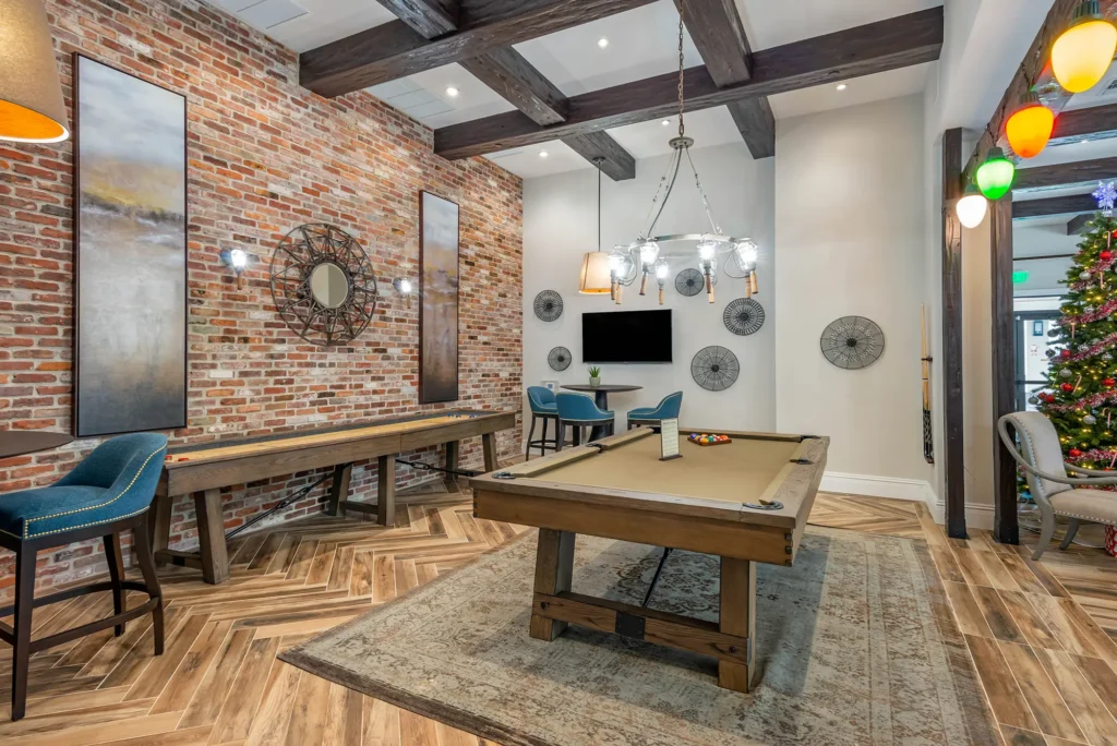 Indoor clubhouse area with pool table and shuffleboard table.