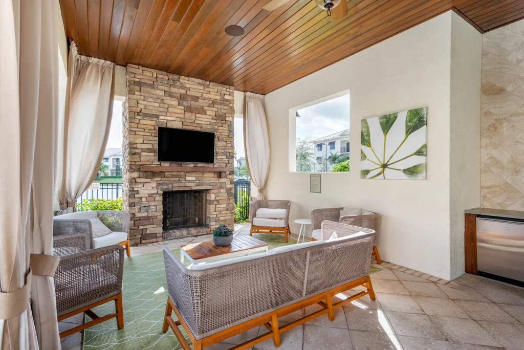Outdoor covered seating space with tv and fireplace