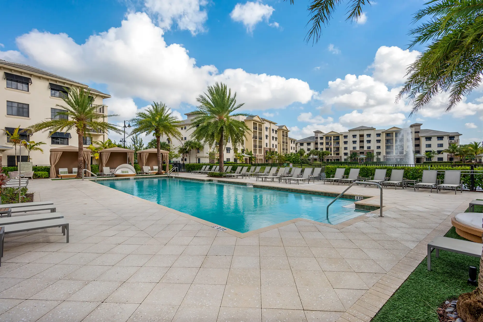 Pool with deck seating and covered cabanas.