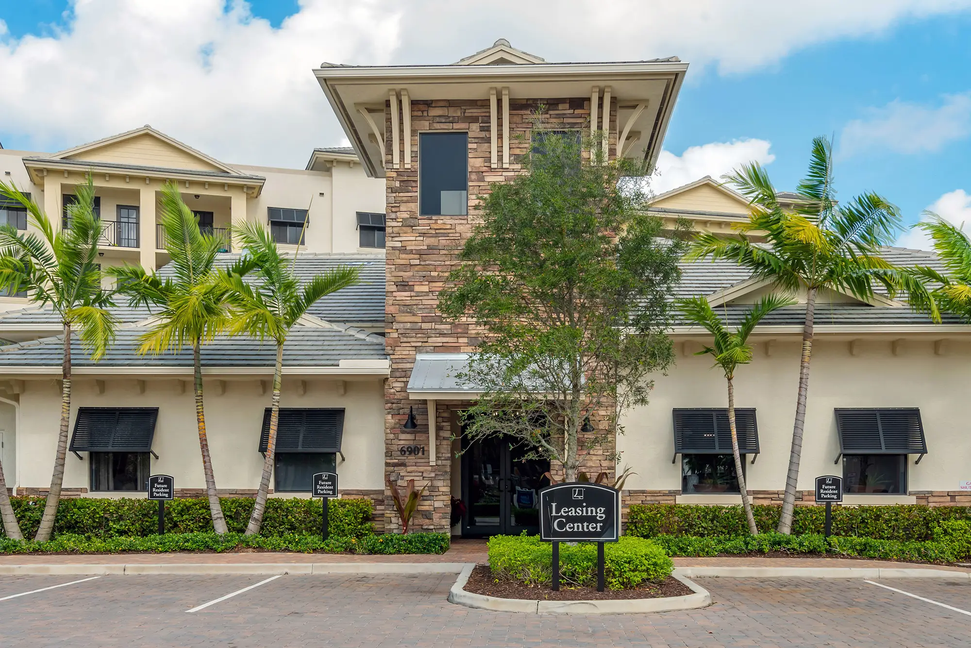 Leasing center exterior with palm trees.